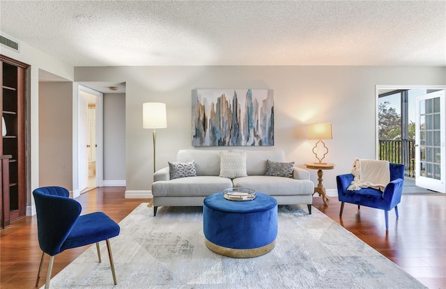 14820 Rue De Bayonne Unit 208, Clearwater, FL 33762 - living room featuring visible vents, a textured ceiling, baseboards, and wood finished floors