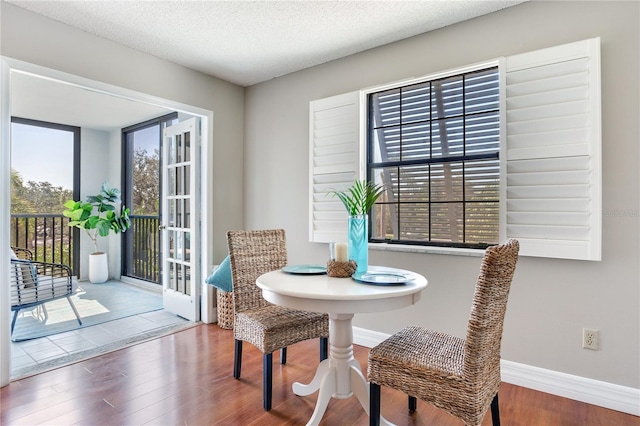 14820 Rue De Bayonne Unit 208, Clearwater, FL 33762 - dining space featuring baseboards, wood finished floors, and french doors