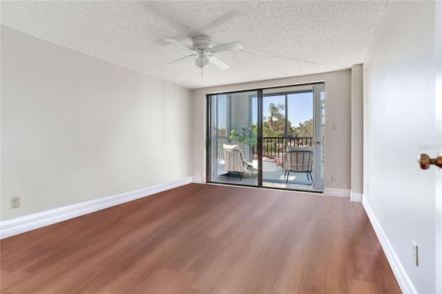14820 Rue De Bayonne Unit 208, Clearwater, FL 33762 - unfurnished room featuring a textured ceiling, ceiling fan, baseboards, and wood finished floors