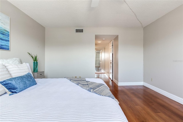 14820 Rue De Bayonne Unit 208, Clearwater, FL 33762 - bedroom with visible vents, wood finished floors, baseboards, a textured ceiling, and a ceiling fan