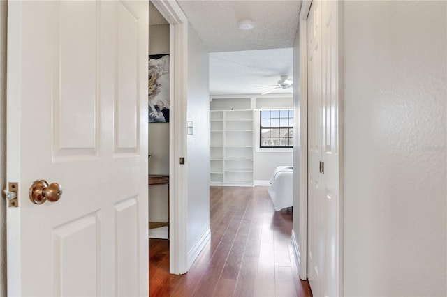 14820 Rue De Bayonne Unit 208, Clearwater, FL 33762 - hall featuring baseboards, a textured ceiling, built in features, and wood finished floors