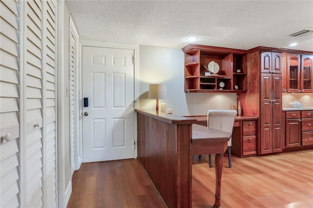 14820 Rue De Bayonne Unit 208, Clearwater, FL 33762 - home office with visible vents, a textured ceiling, and light wood finished floors