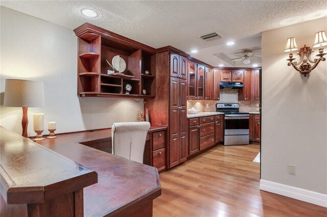 14820 Rue De Bayonne Unit 208, Clearwater, FL 33762 - kitchen with light wood-style floors, a textured ceiling, electric stove, backsplash, and visible vents