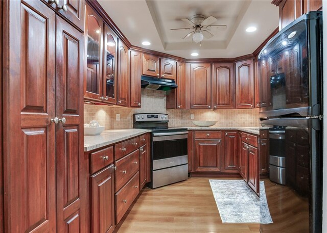 14820 Rue De Bayonne Unit 208, Clearwater, FL 33762 - kitchen featuring a ceiling fan, light stone countertops, a raised ceiling, stainless steel electric stove, and under cabinet range hood
