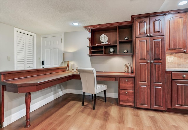 14820 Rue De Bayonne Unit 208, Clearwater, FL 33762 - office space featuring light wood-style floors, baseboards, a textured ceiling, and built in desk