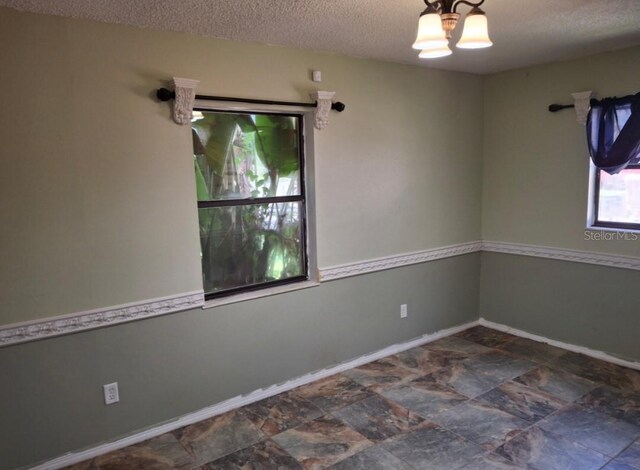 11305 SW 186th Cir, Dunnellon, FL 34432 - empty room with a textured ceiling, baseboards, and stone finish flooring