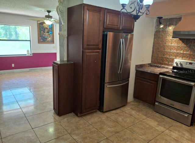 11305 SW 186th Cir, Dunnellon, FL 34432 - kitchen with stainless steel appliances, wall chimney exhaust hood, decorative backsplash, and light tile patterned floors