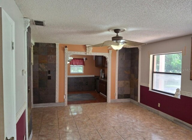 11305 SW 186th Cir, Dunnellon, FL 34432 - empty room with a ceiling fan, a textured ceiling, light tile patterned flooring, and baseboards