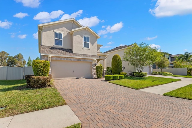 view of front of home with a garage, decorative driveway, fence, stone siding, and stucco siding