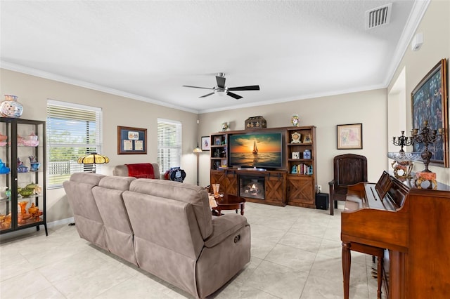 living room with visible vents, ornamental molding, a ceiling fan, and light tile patterned floors