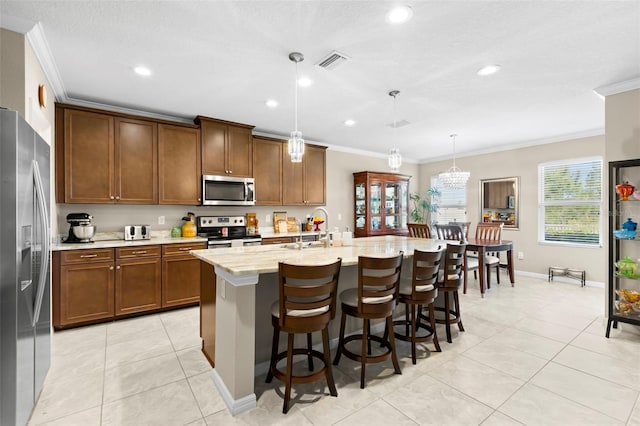 kitchen with appliances with stainless steel finishes, ornamental molding, a sink, and visible vents