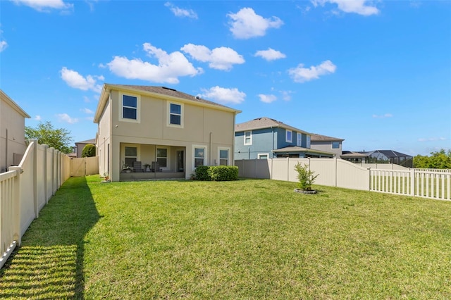 back of property featuring a fenced backyard, stucco siding, and a yard