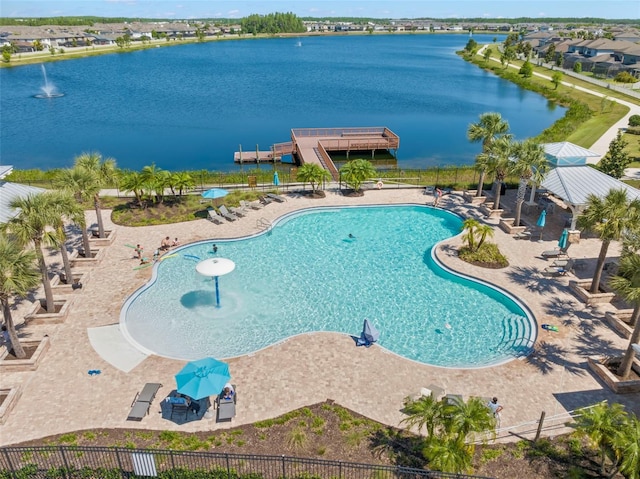 pool featuring a water view, fence, and a patio