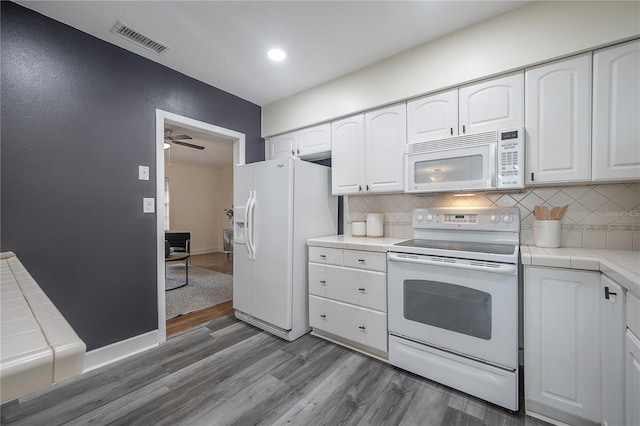 1211 E Park Cir, Tampa, FL 33604 - kitchen featuring white appliances, tile counters, wood finished floors, backsplash, and recessed lighting