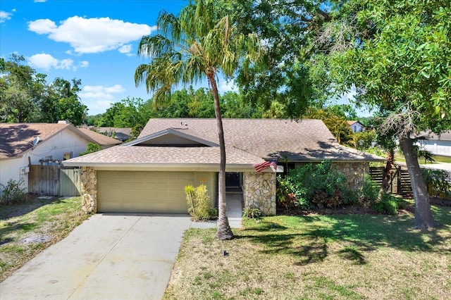 view of front of house with roof with shingles, fence, an attached garage, and stone siding