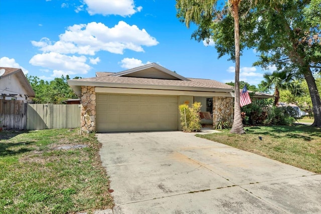 ranch-style home with concrete driveway, stone siding, an attached garage, and a front yard