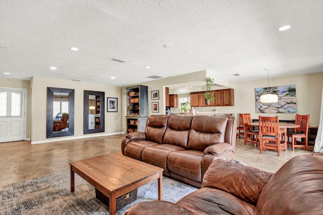living area with visible vents, recessed lighting, a textured ceiling, and baseboards