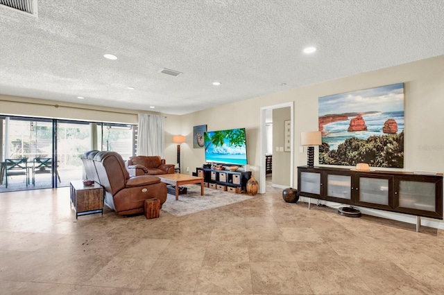 living area with recessed lighting, a textured ceiling, and visible vents