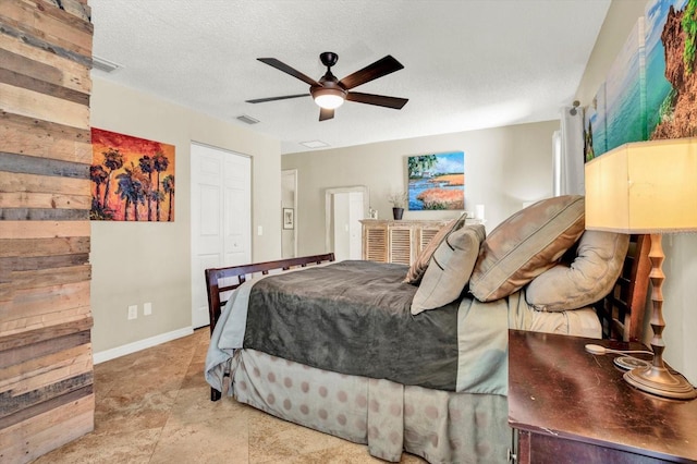 bedroom featuring visible vents, a textured ceiling, ceiling fan, and a closet