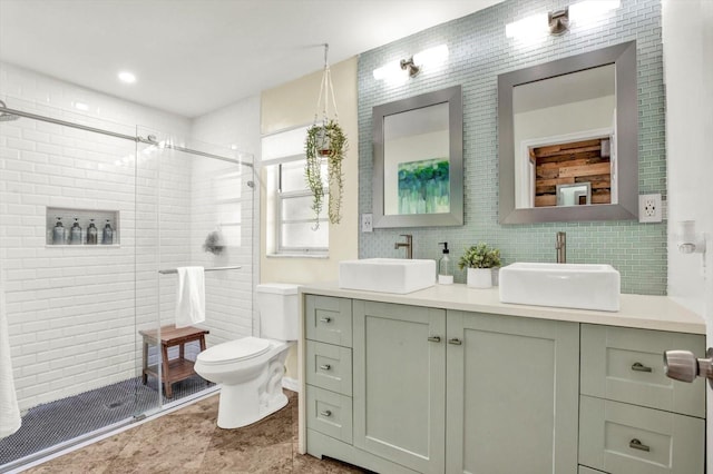full bathroom featuring double vanity, a sink, a stall shower, and toilet
