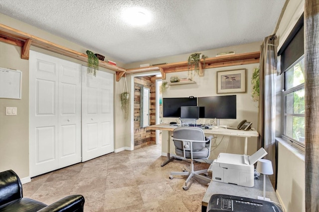 office space featuring a textured ceiling, baseboards, and plenty of natural light