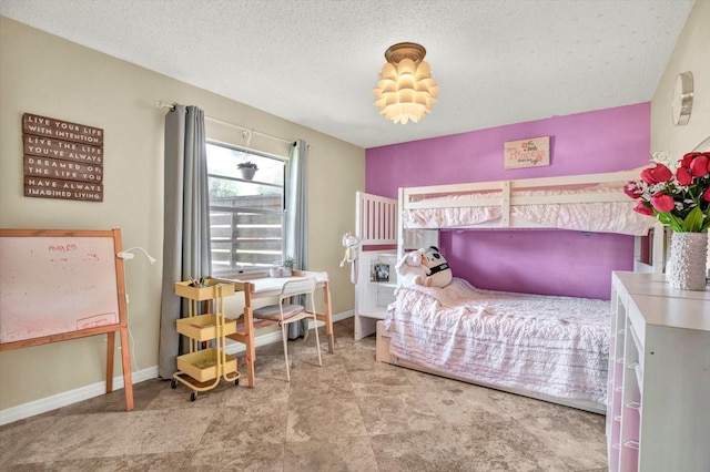 bedroom with a textured ceiling and baseboards