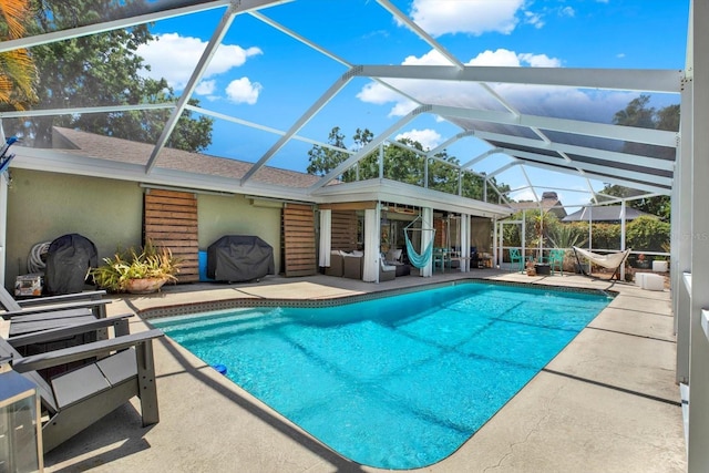 pool with glass enclosure and a patio