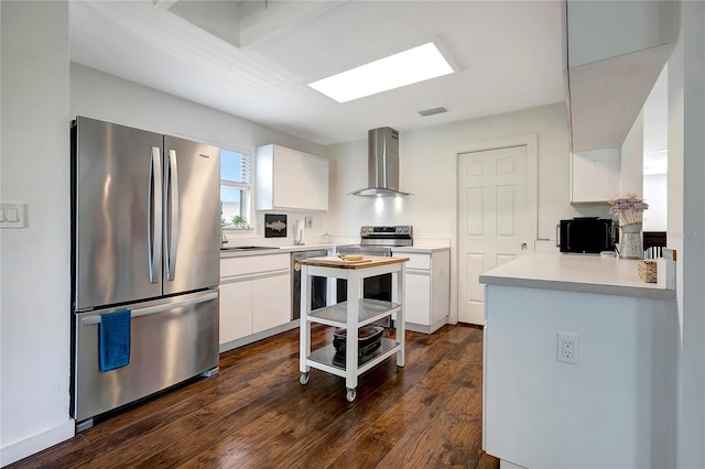 13974 75th Ave, Seminole, FL 33776 - kitchen with stainless steel appliances, wall chimney exhaust hood, white cabinetry, a sink, and dark wood-style floors