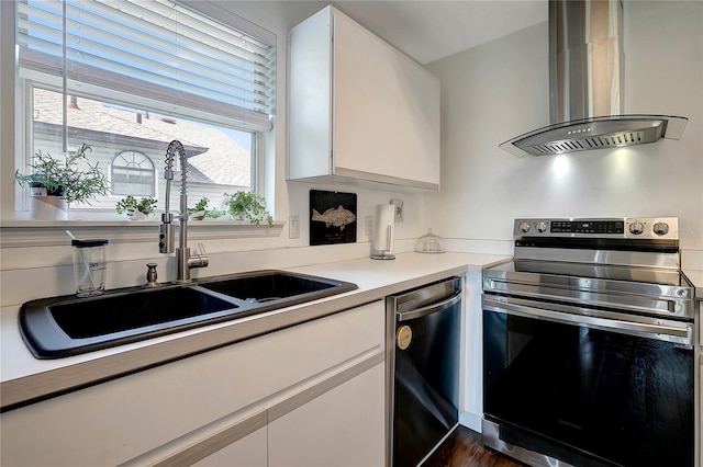 13974 75th Ave, Seminole, FL 33776 - kitchen featuring appliances with stainless steel finishes, wall chimney range hood, and white cabinets
