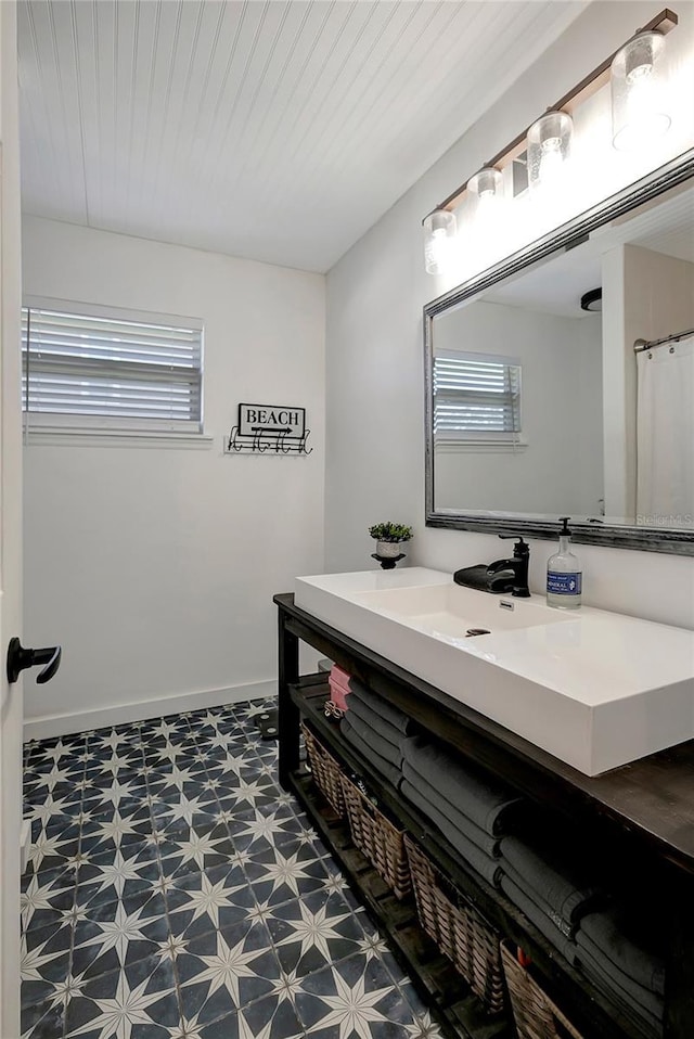 13974 75th Ave, Seminole, FL 33776 - bathroom with tile patterned floors, healthy amount of natural light, vanity, and baseboards
