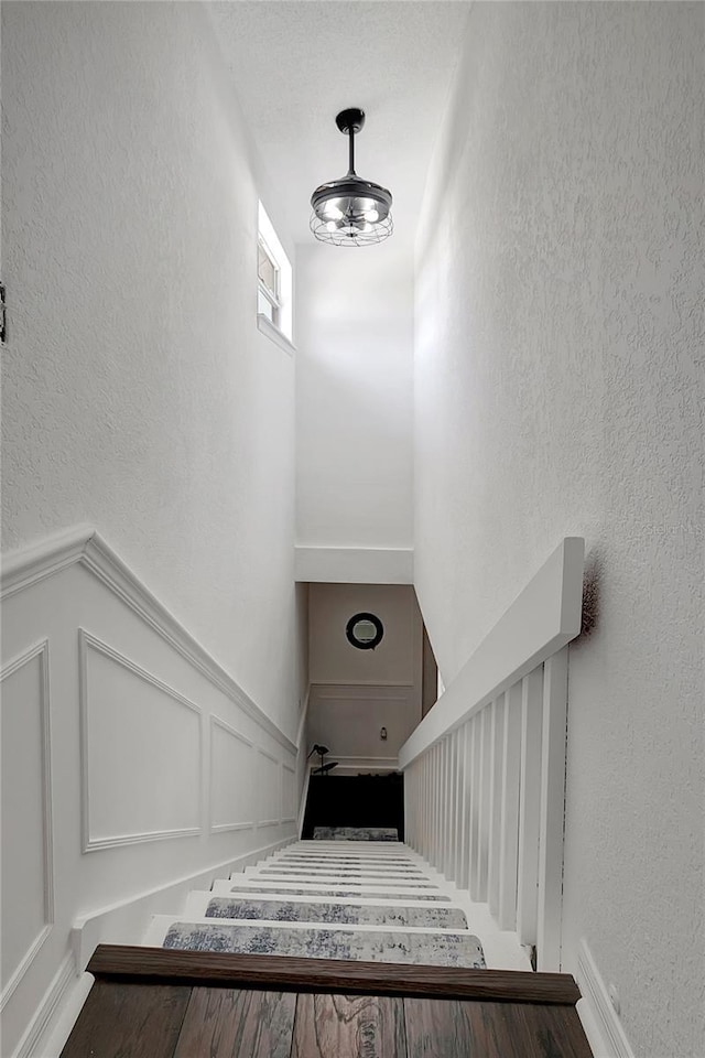 13974 75th Ave, Seminole, FL 33776 - stairs featuring a textured wall, a towering ceiling, and a decorative wall
