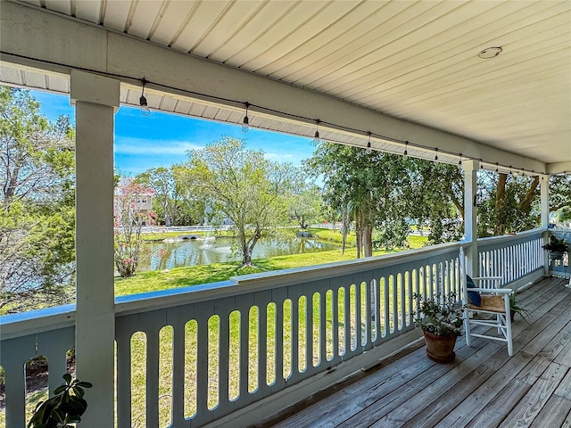 13974 75th Ave, Seminole, FL 33776 - wooden deck with a water view, covered porch, and a yard