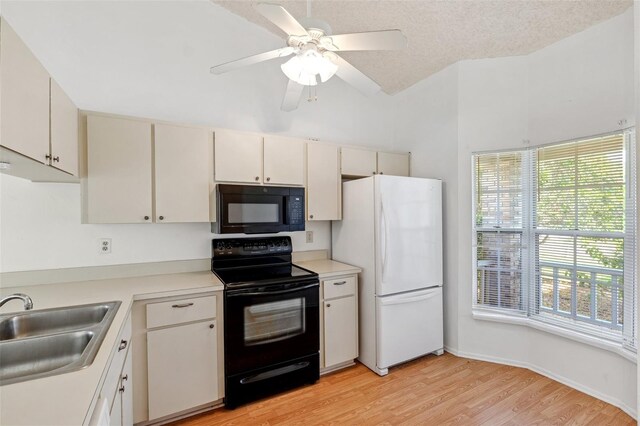 kitchen with black appliances, a sink, light wood-style floors, and light countertops