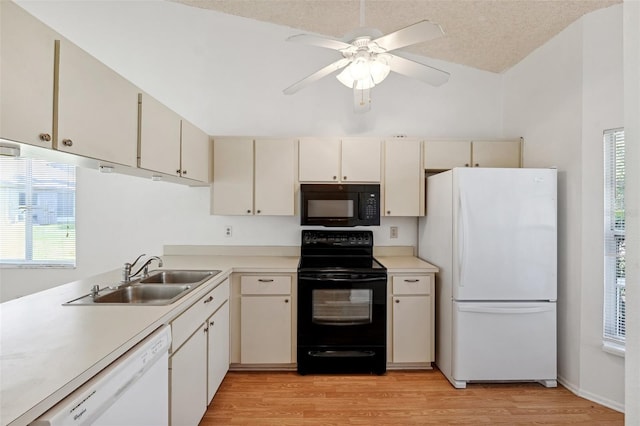 kitchen with black appliances, a sink, light wood finished floors, a ceiling fan, and light countertops