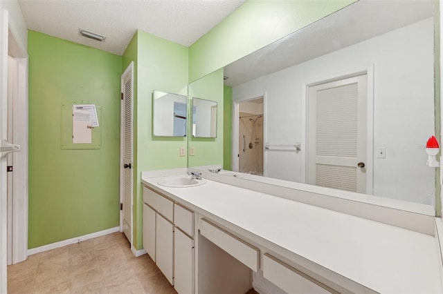 bathroom with vanity, baseboards, and a closet