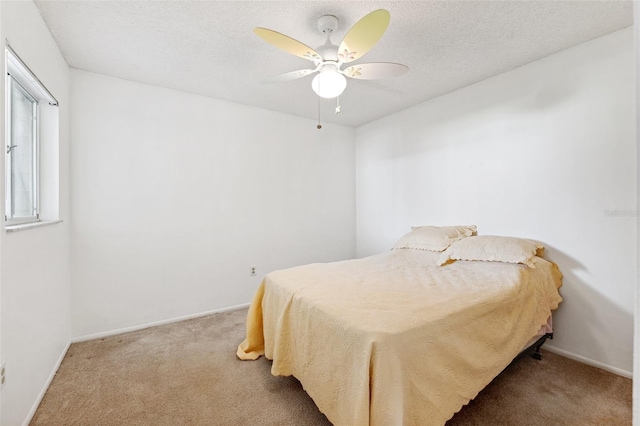 bedroom with carpet floors, baseboards, a ceiling fan, and a textured ceiling