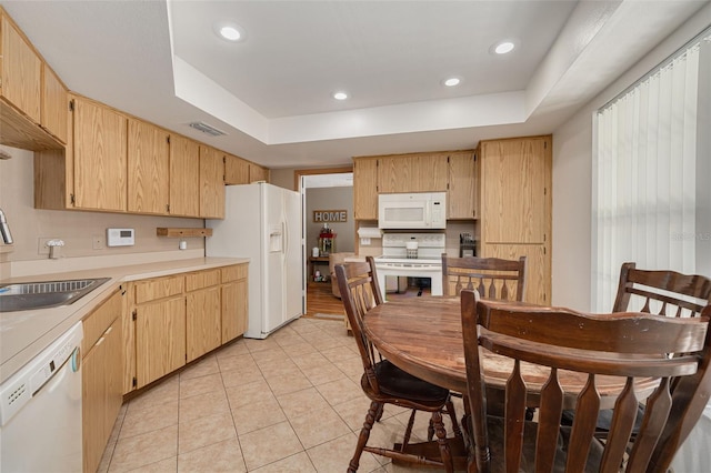 2153 Catalina Dr N, Clearwater, FL 33763 - kitchen with white appliances, a sink, light tile patterned flooring, light countertops, and a tray ceiling