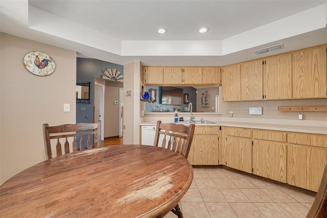 2153 Catalina Dr N, Clearwater, FL 33763 - kitchen featuring light brown cabinetry, a sink, a tray ceiling, light countertops, and light tile patterned floors