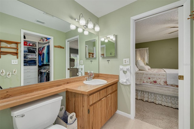 2153 Catalina Dr N, Clearwater, FL 33763 - bathroom with ensuite bathroom, toilet, vanity, tile patterned flooring, and a walk in closet