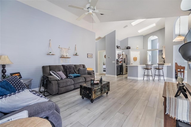 18013 Palm Breeze Dr, Tampa, FL 33647 - living area with ceiling fan, light wood-style floors, high vaulted ceiling, baseboards, and a skylight