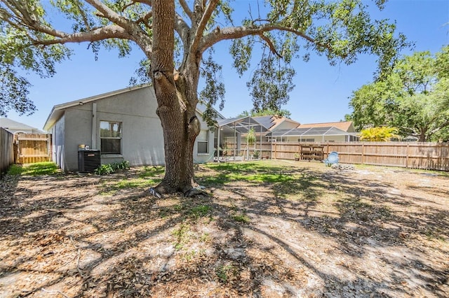 18013 Palm Breeze Dr, Tampa, FL 33647 - view of yard featuring a fenced backyard, glass enclosure, and central AC