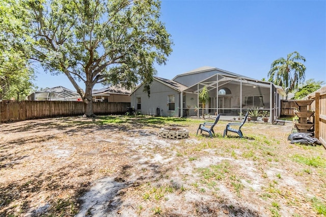 18013 Palm Breeze Dr, Tampa, FL 33647 - rear view of property featuring a lanai, a fenced backyard, and an outdoor fire pit