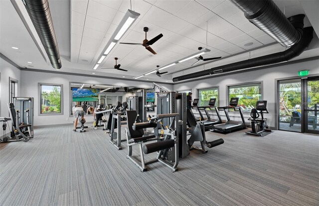 exercise room with carpet floors, ceiling fan, and baseboards