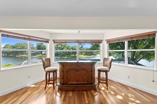 sunroom / solarium featuring a water view
