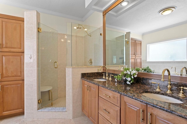 full bath with ornamental molding, a sink, and a stall shower