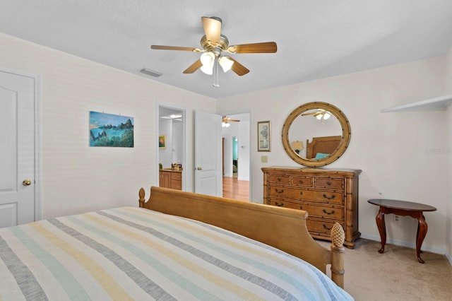 bedroom featuring visible vents, baseboards, ceiling fan, and light carpet