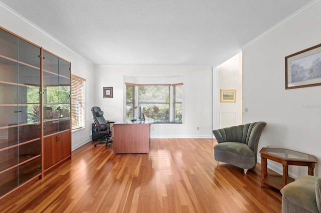 home office with baseboards, ornamental molding, and light wood-style flooring