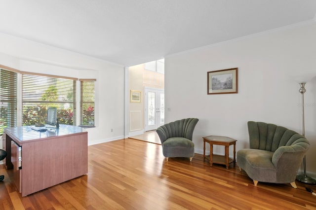 living area with crown molding, a wealth of natural light, and light wood-style floors
