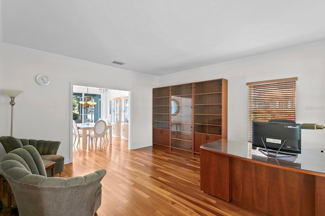 office area with visible vents, ornamental molding, wood finished floors, and a chandelier