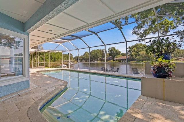 pool featuring glass enclosure, a water view, and a patio area